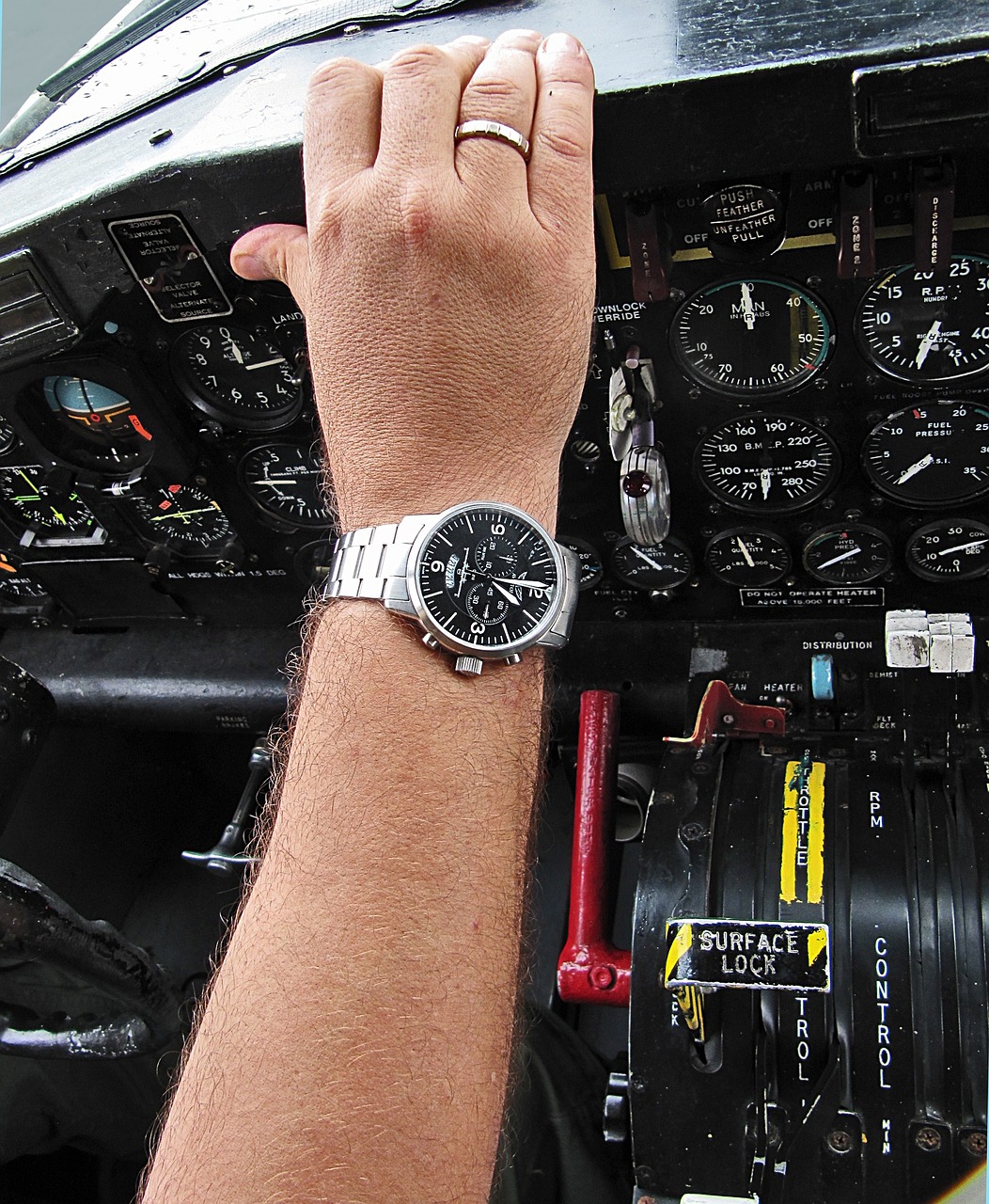 Pilot wearing a watch resting his hand on the glareshield.